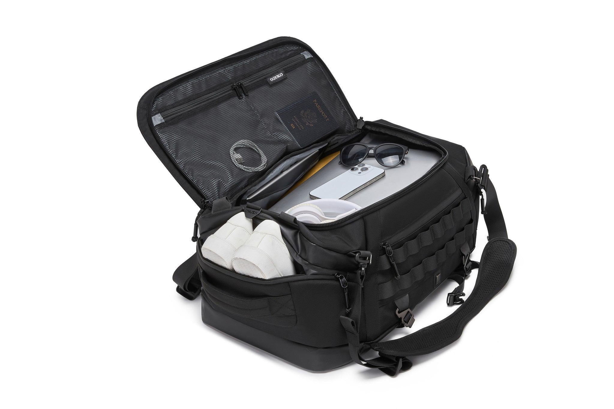 Interior lid pocket packed with a passport, sunglasses, a phone, a laptop, and white sneakers