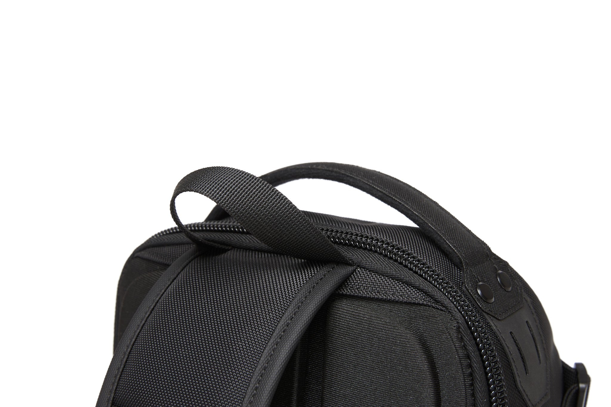 Ridge Sling Backpack 12L in Black - close-up of the top carry handle and dual-pull zipper hardware