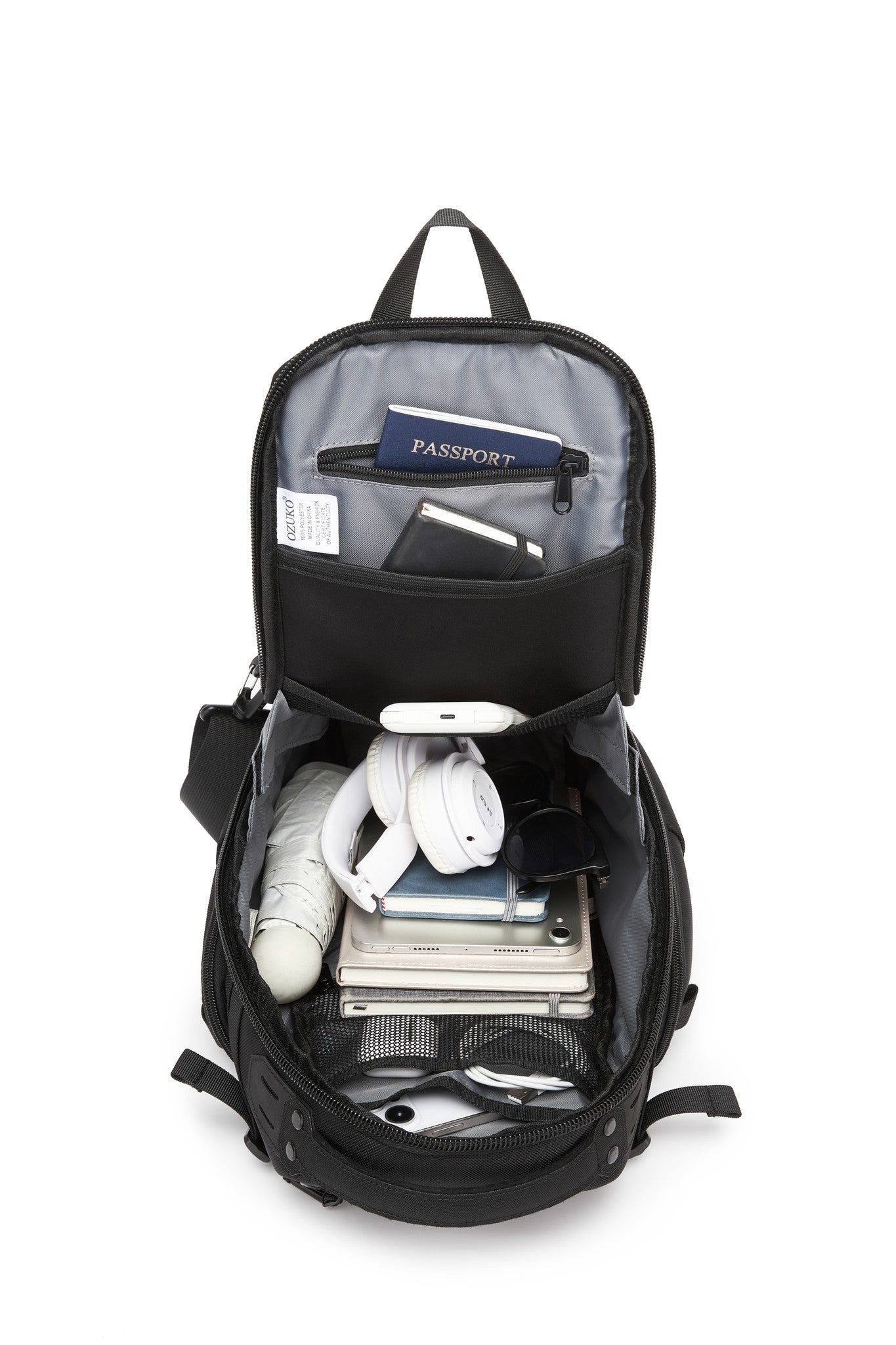 Ridge Sling Backpack 12L in Black - top-down view of the fully packed main compartment with a passport, notebook, headphones, sunglasses, and umbrella