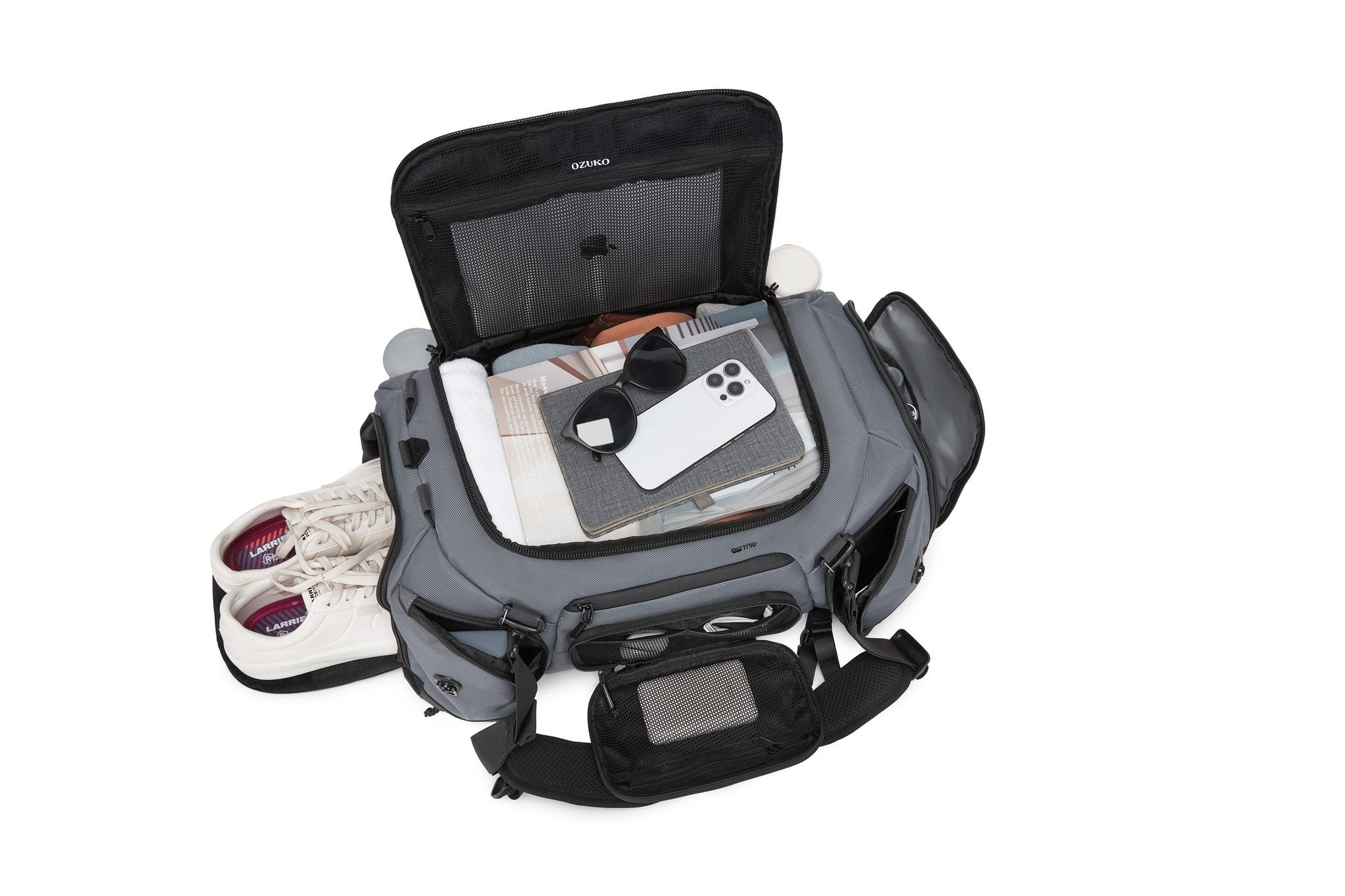 Interior lid pocket packed with white sneakers, a notebook, sunglasses, and a phone, Gray exterior visible at the edges