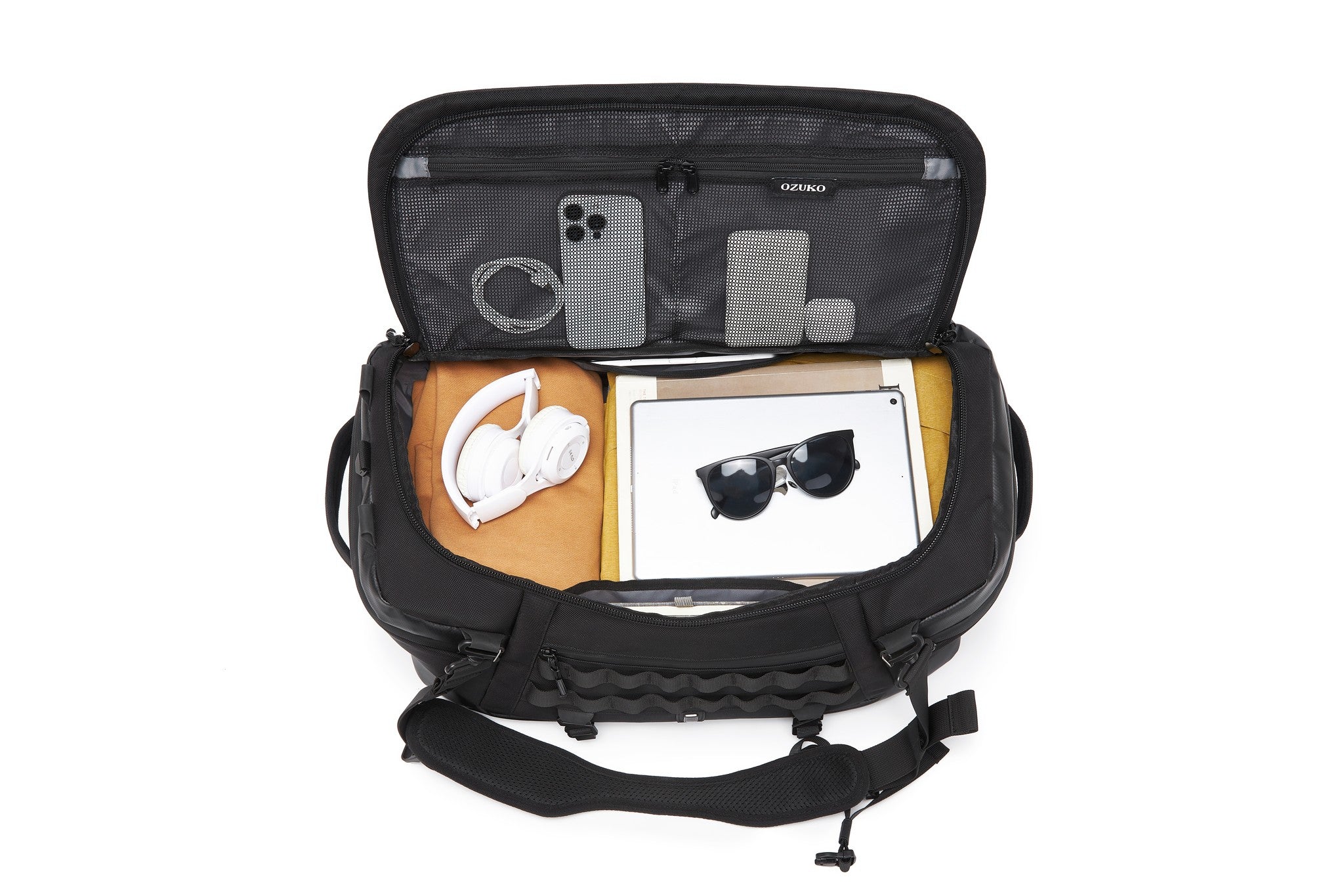 Interior packed with headphones, a tablet, sunglasses, and a phone in the mesh lid pocket, showing the OZUKO branding tag